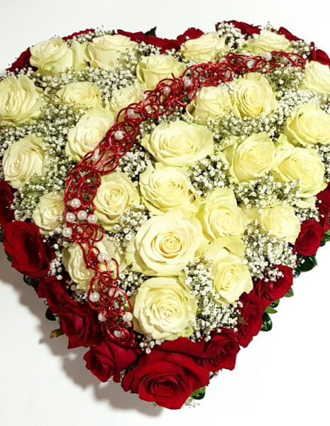Composizione di rose rosse e bianche con gypsophila compatta a forma di cuore