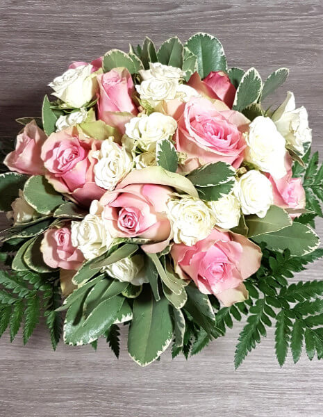 Bouquet di rose rosa e bianche con verdi decorativi